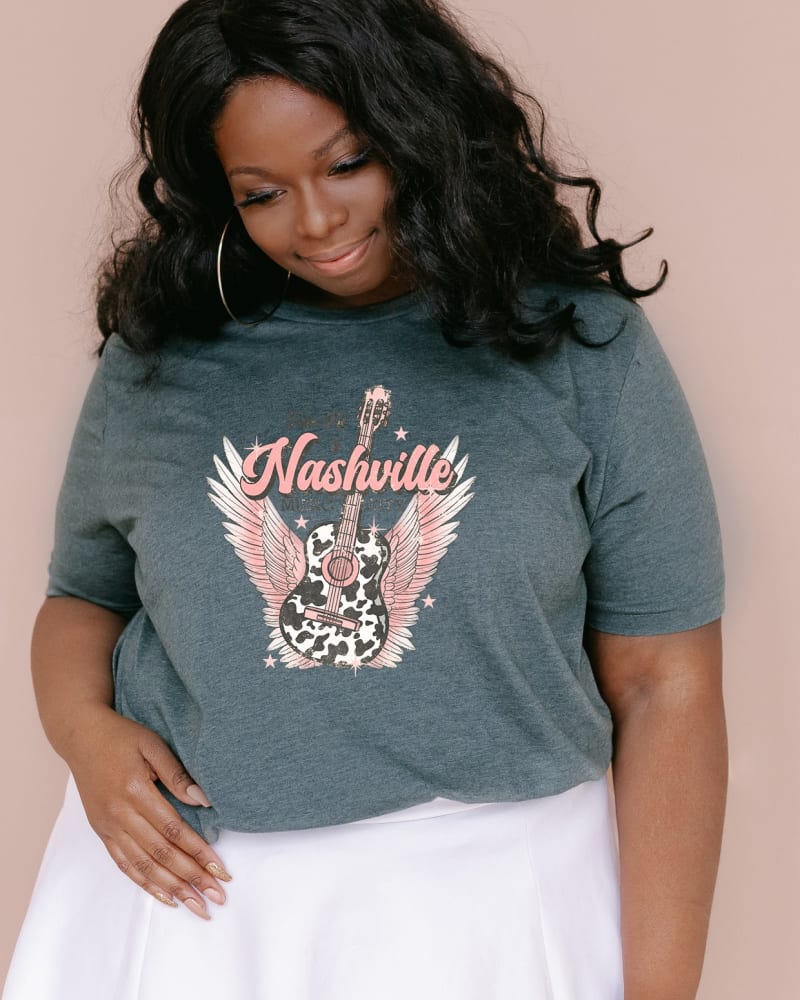Front of a model wearing a size 2XL Take Me To Nashville Winged Guitar in Forest by Simply Sage Market. | dia_product_style_image_id:281612
